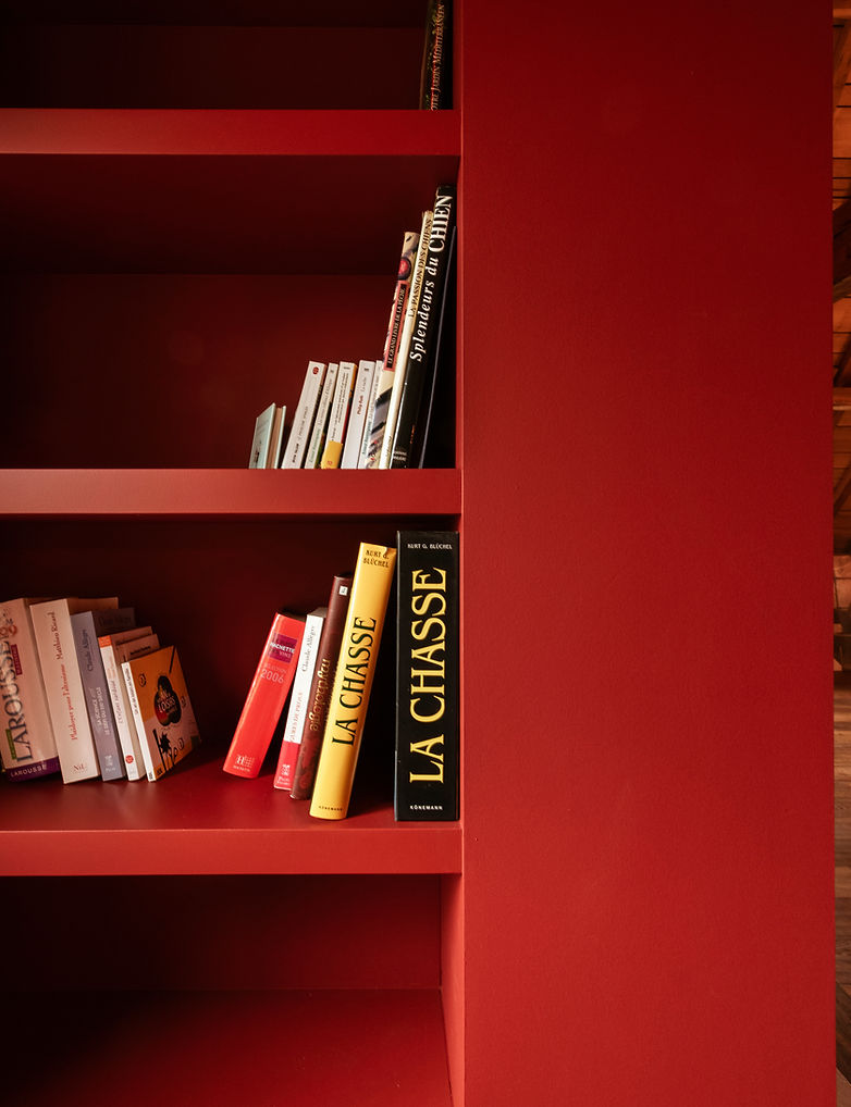 Detail van boekenkast in warm rood geschilderd